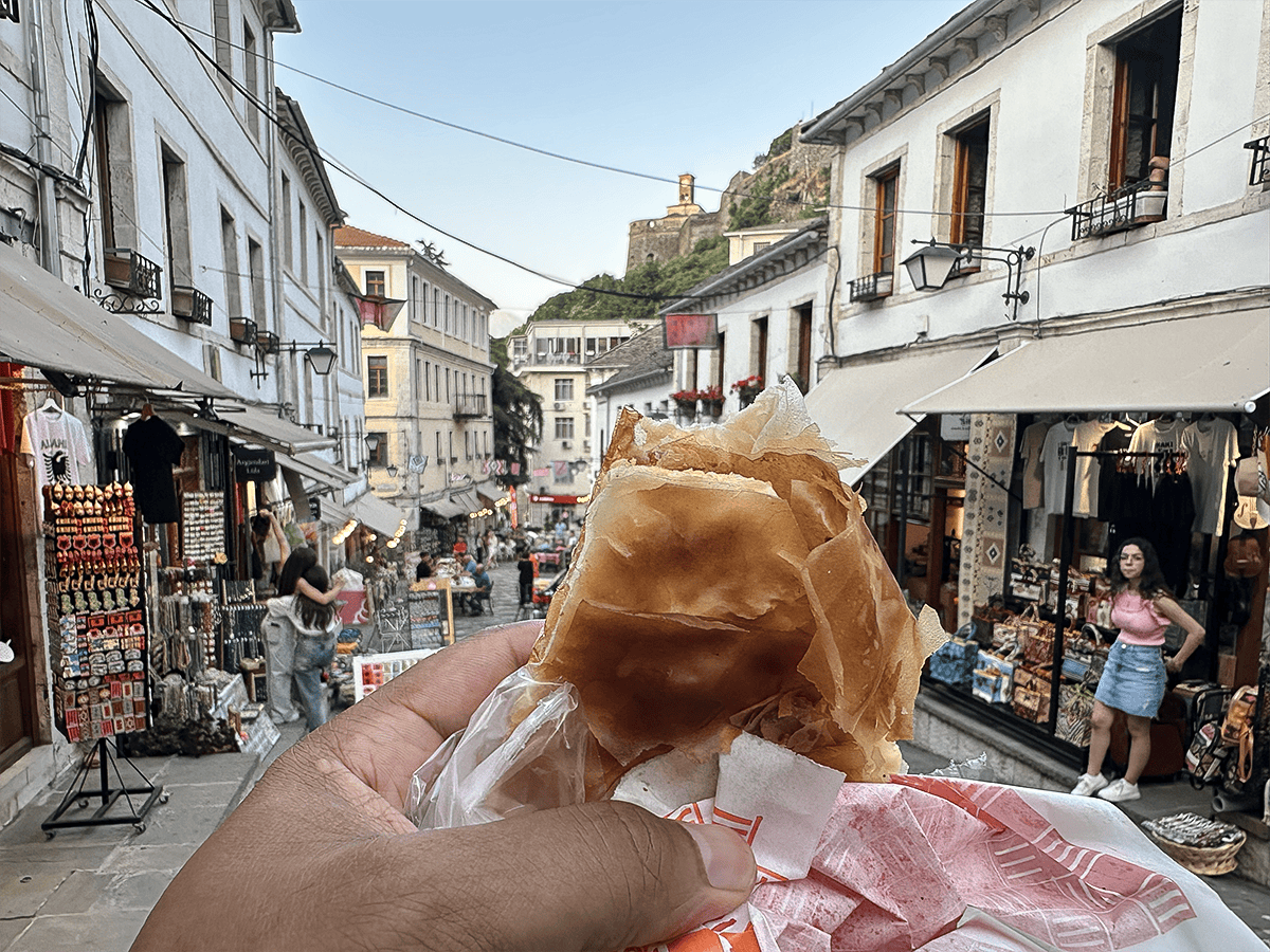 Eating a byrek at Gjirokaster Bazaar